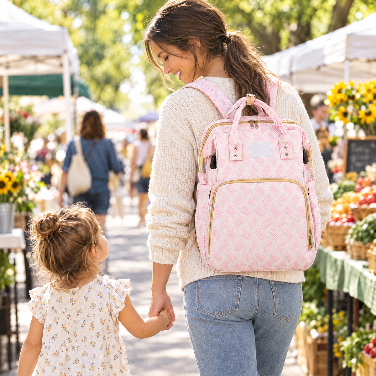 Mom wearing the Nest Backpack at a market with her toddler